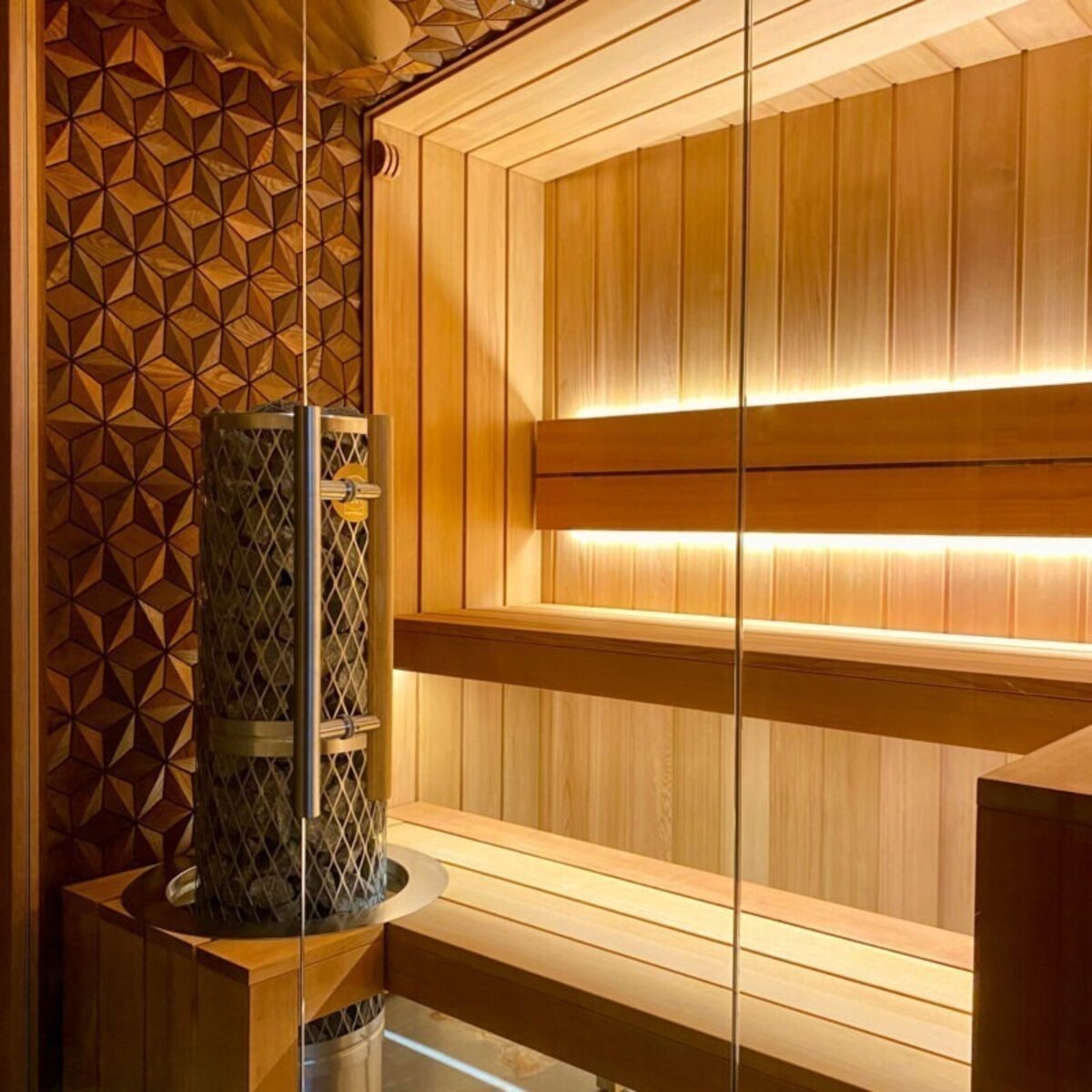 Sauna with light wood diamond-pattern paneling and a cylindrical heater